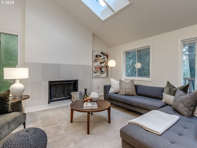 living room with a skylight and high vaulted ceiling