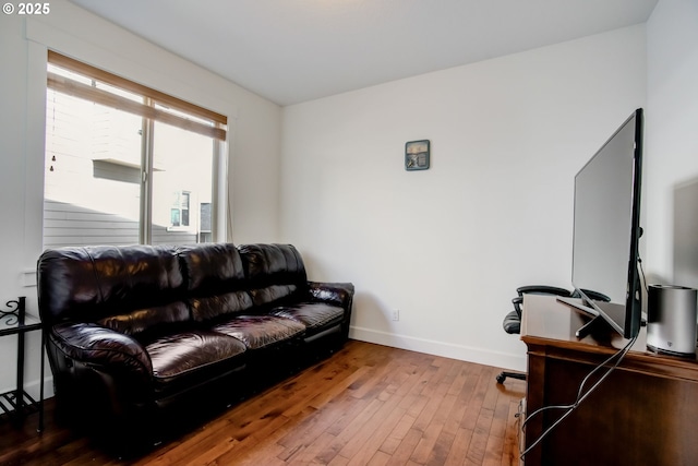 living area featuring hardwood / wood-style floors and baseboards
