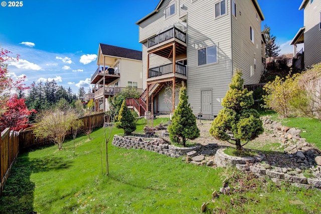 rear view of property with a yard, stairway, a fenced backyard, and a balcony