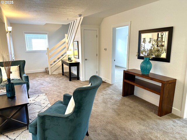 sitting room featuring baseboards, stairs, a textured ceiling, and carpet