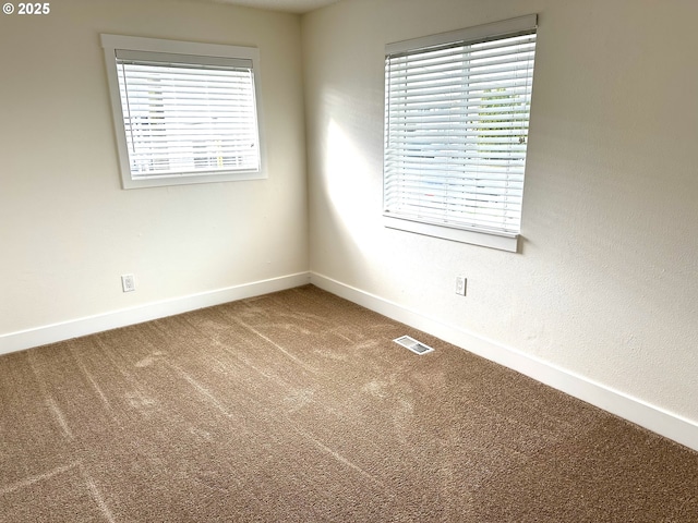 carpeted empty room with baseboards and visible vents