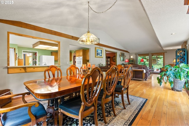 dining room featuring lofted ceiling and light wood-type flooring