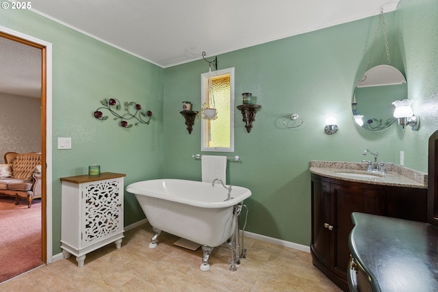 bathroom with a freestanding bath, vanity, baseboards, and crown molding