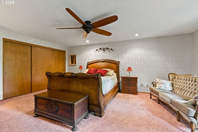 bedroom featuring light colored carpet, recessed lighting, a closet, a textured ceiling, and a ceiling fan