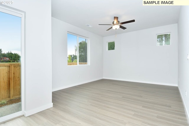 empty room featuring ceiling fan, a healthy amount of sunlight, and light hardwood / wood-style floors