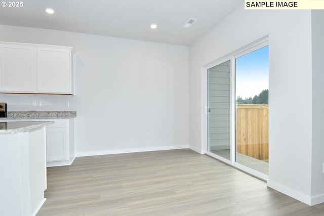 unfurnished dining area with light wood-type flooring