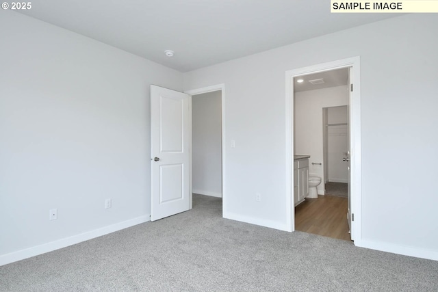 unfurnished bedroom with light colored carpet and ensuite bath