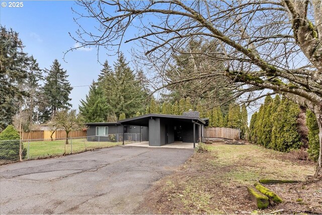 exterior space with a carport and a lawn