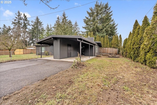 exterior space with a carport and a lawn