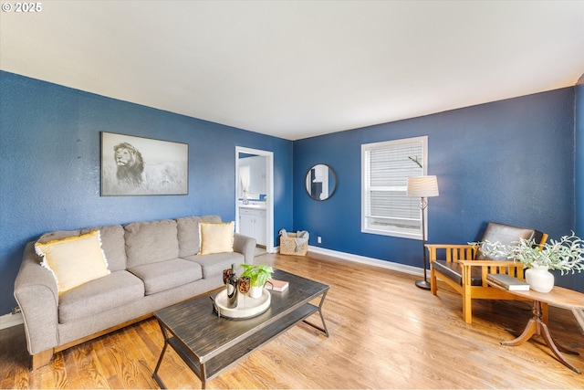 living area with baseboards and wood finished floors