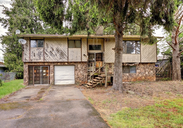 14251 Caufield Rd, Oregon City, OR 97045 - split foyer home featuring stone siding, asphalt driveway, fence, and a garage