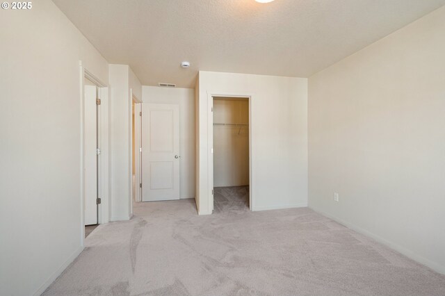 8512 NE 13th Pl, Vancouver, WA 98665 - unfurnished bedroom with light colored carpet, a walk in closet, a closet, and a textured ceiling