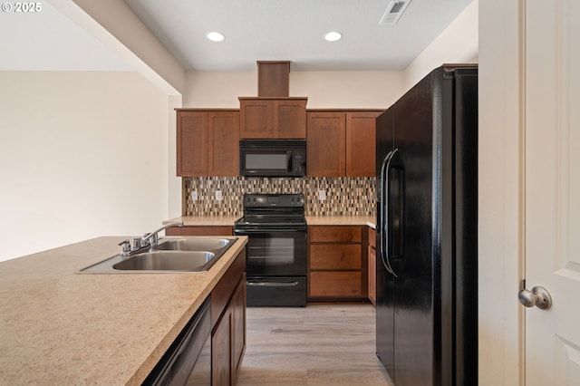 8512 NE 13th Pl, Vancouver, WA 98665 - kitchen featuring black appliances, light wood-style floors, light countertops, decorative backsplash, and brown cabinets