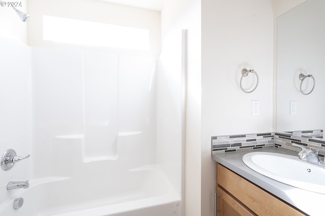 bathroom featuring vanity, decorative backsplash, and bathing tub / shower combination