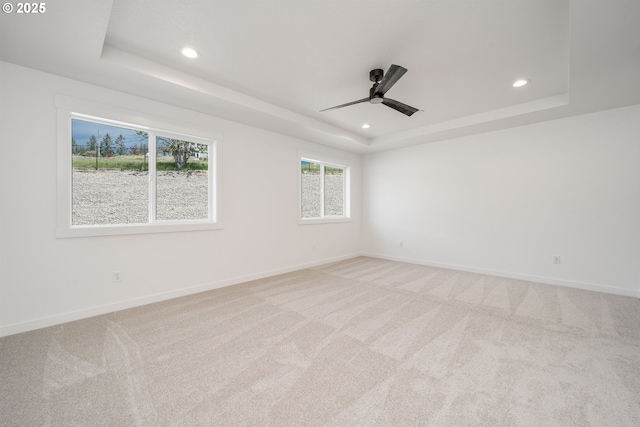 spare room with a tray ceiling, a ceiling fan, recessed lighting, and light colored carpet