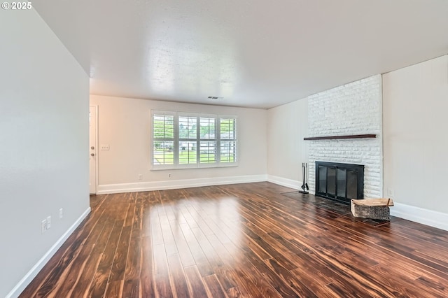 575 NE Fleming Ave Unit B-43, Gresham, OR 97030 - unfurnished living room featuring dark wood-type flooring, a brick fireplace, and baseboards