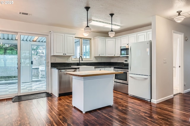 575 NE Fleming Ave Unit B-43, Gresham, OR 97030 - kitchen featuring stainless steel appliances, a sink, healthy amount of natural light, dark wood finished floors, and a textured ceiling