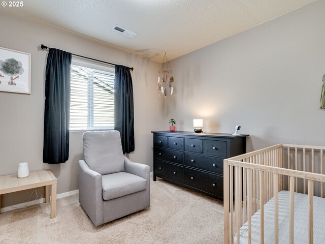 11411 NE 131st Pl, Vancouver, WA 98682 - bedroom featuring baseboards, a crib, a textured ceiling, visible vents, and light colored carpet