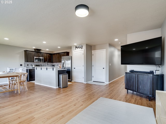 11411 NE 131st Pl, Vancouver, WA 98682 - kitchen with stainless steel appliances, open floor plan, light wood-style flooring, and dark brown cabinetry