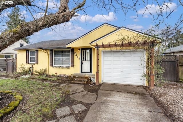 ranch-style home with concrete driveway, an attached garage, fence, and stucco siding