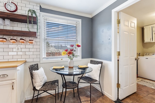 dining room with tile patterned flooring, crown molding, a wainscoted wall, breakfast area, and washer / dryer