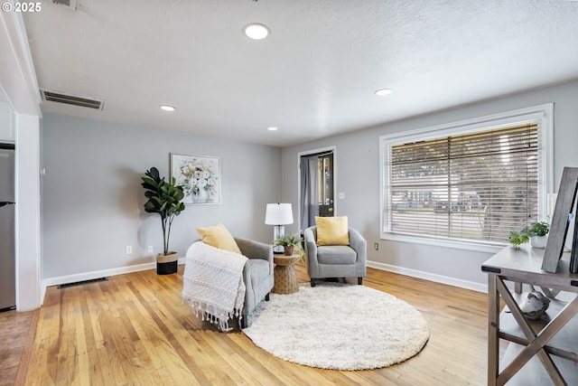 sitting room with recessed lighting, light wood-style floors, visible vents, and baseboards