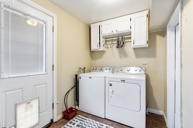 clothes washing area featuring cabinet space, independent washer and dryer, and baseboards