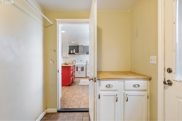 doorway featuring light tile patterned floors and baseboards