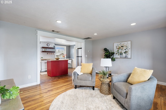 sitting room featuring visible vents, recessed lighting, light wood-type flooring, and baseboards