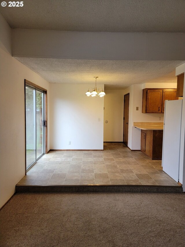 interior space featuring a chandelier, light carpet, and a textured ceiling