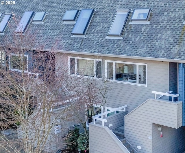 rear view of property featuring roof with shingles