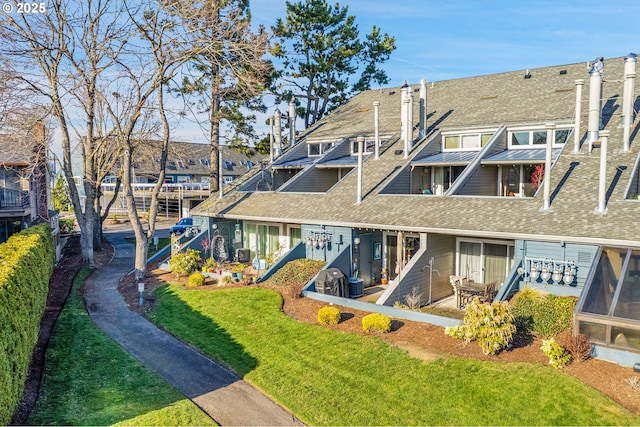 back of property featuring a yard, roof with shingles, and cooling unit