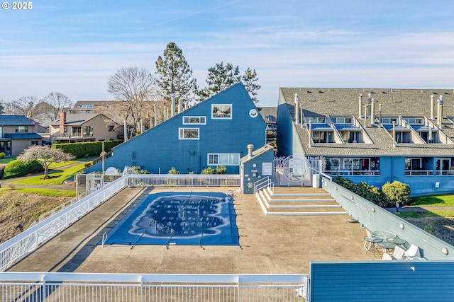 view of swimming pool featuring a residential view and fence