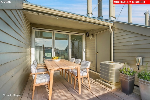 wooden deck with outdoor dining area and central AC unit