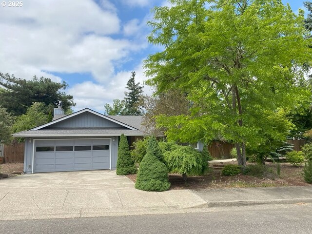 215 NE 9th St, Oakland, OR 97462 - ranch-style home with concrete driveway, a garage, a chimney, and roof with shingles