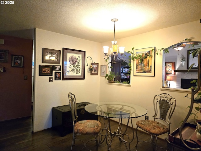 dining space featuring a textured ceiling, a chandelier, and dark hardwood / wood-style floors