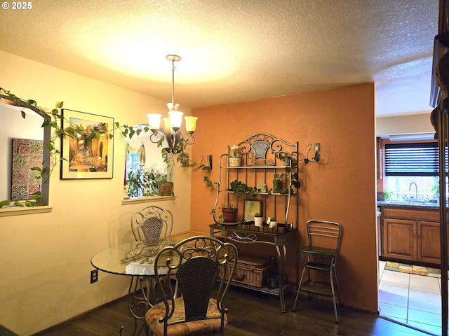 dining room with a notable chandelier, dark hardwood / wood-style floors, and a textured ceiling