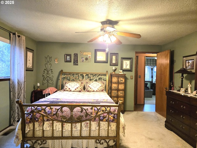 bedroom featuring ceiling fan, a textured ceiling, and light carpet