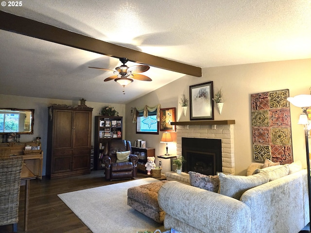 living room featuring ceiling fan, lofted ceiling with beams, dark hardwood / wood-style floors, a textured ceiling, and a fireplace