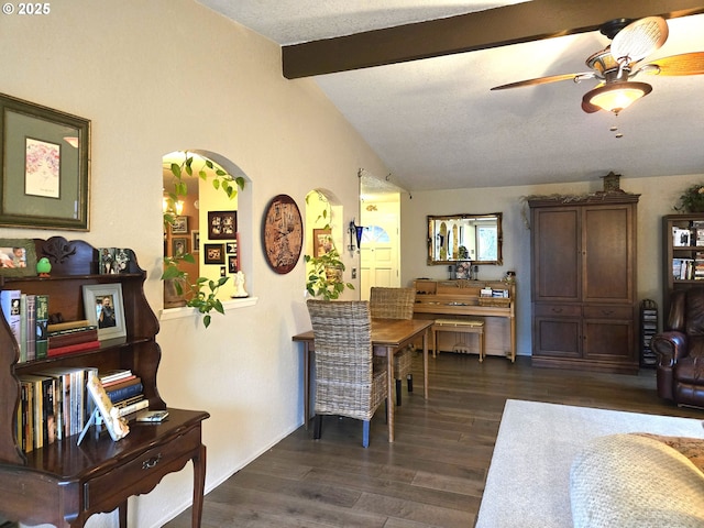 dining space featuring vaulted ceiling with beams, ceiling fan, dark hardwood / wood-style flooring, and a textured ceiling