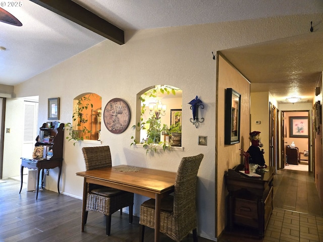 dining room featuring vaulted ceiling with beams, dark hardwood / wood-style flooring, and a textured ceiling