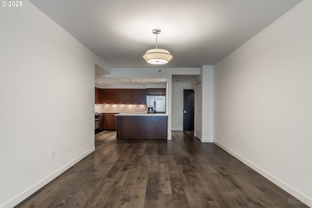 kitchen featuring dark hardwood / wood-style floors, dark brown cabinetry, stainless steel fridge, and a kitchen island