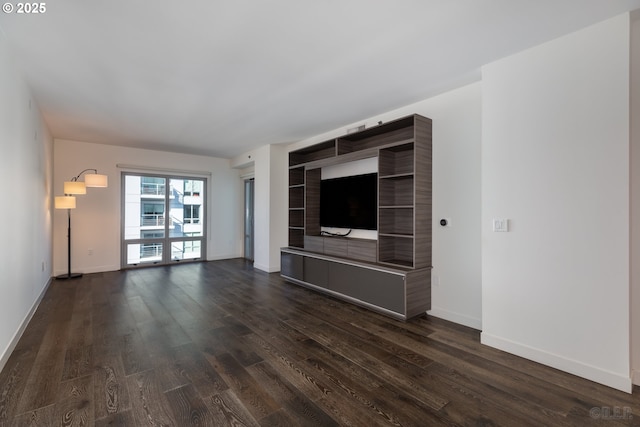 unfurnished living room with dark wood-type flooring