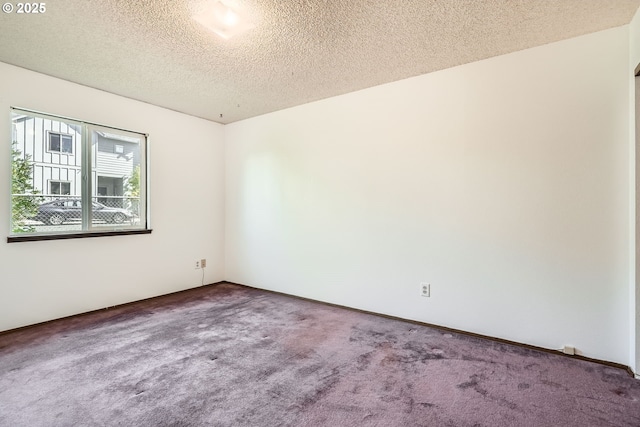 carpeted empty room with a textured ceiling