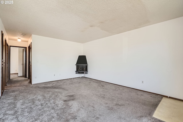 carpeted empty room with a textured ceiling