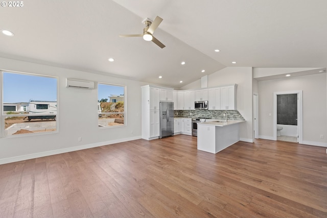 30403 Sawyer Way, Gold Beach, OR 97444 - kitchen with stainless steel appliances, a wall mounted air conditioner, vaulted ceiling, open floor plan, and ceiling fan