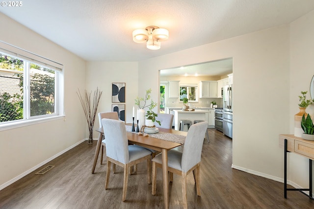dining area with baseboards, dark wood-type flooring, and visible vents