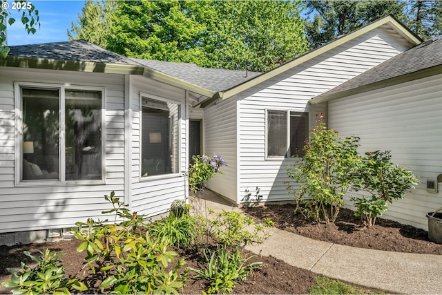 view of side of home with a shingled roof