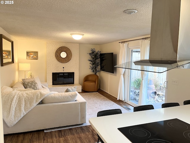 living room featuring a textured ceiling, wood finished floors, and a fireplace