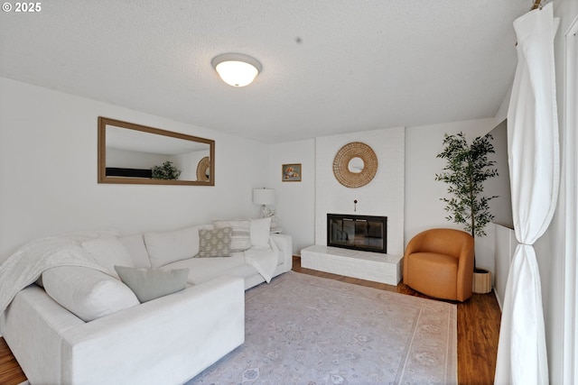 3138 Kentwood Dr, Eugene, OR 97401 - living room with wood finished floors, a fireplace, and a textured ceiling